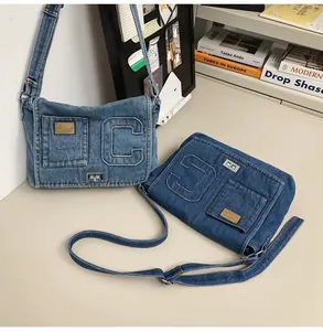 Close-up of vintage denim shoulder bag with metal twist lock and letter C decoration