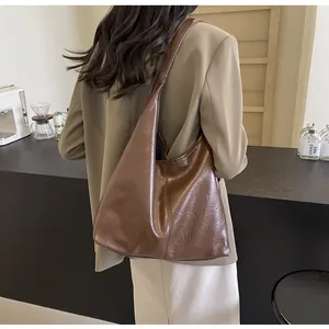 Détail du grand sac cabas marron foncé montrant la texture plissée rétro sur le modèle