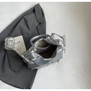 Detail of silver metallic tote bag showing zip closure, bow decor and light fabric lining
