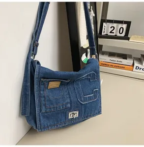 Detail of blue denim shoulder bag with embossed letter C and silver metal twist lock