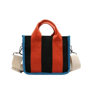 Minimalistische canvas shopper in zwart en oranje met blauwe bies en verstelbare riem