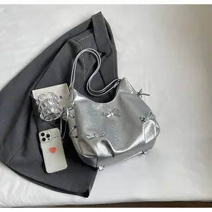 Macro shot of silver crescent hobo bag with metallic bows and drawstring details