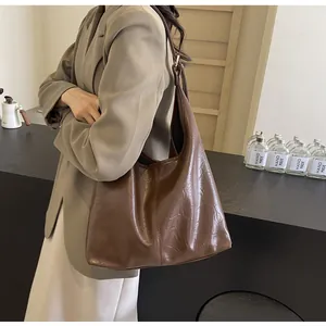 Détail du sac cabas en similicuir marron foncé avec texture plissée et large bandoulière