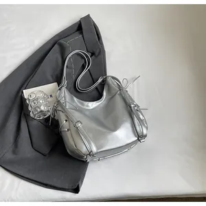 Detailed close-up of metallic silver tote bag with drawstring and buckle strap texture