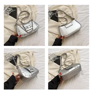 Detail view of silver crocodile texture shoulder bag with heart-shaped metal buckle and chain