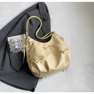 Detail of butter yellow wrinkled hobo bag with a delicate ribbon and drawstring detail