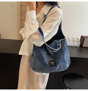 Lifestyle view of large denim tote bag with black bow patch in a cozy cafe setting