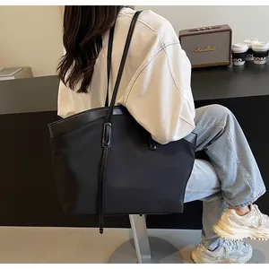 Large capacity black tote bag with leather trim shown in a stylish lifestyle setting