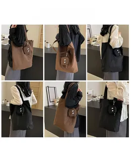Detail showing foldable nylon tote bags with monster eye pouches and metallic hardware