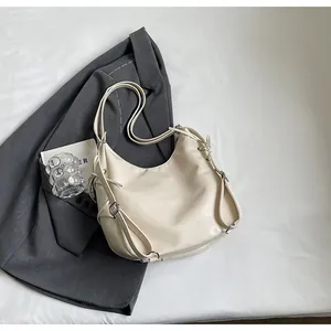 Detail of cream white leather hobo tote showing adjustable buckles and double straps
