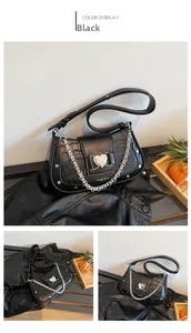 Close-up of black croc-embossed handbag featuring a silver heart buckle and chain
