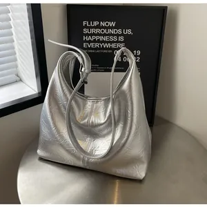 Gros plan du sac cabas argenté métallisé avec texture plissée et sangle réglable