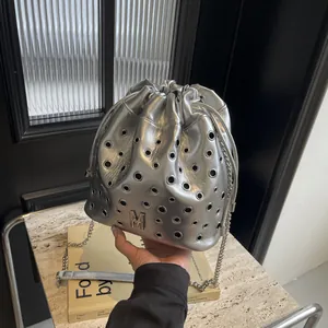 Sac seau argenté chic avec détails d'oeillets et bandoulière en chaîne réglable