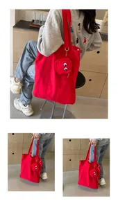 Detail of red canvas tote bag featuring a cute cartoon eye circular coin purse attachment