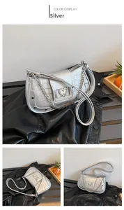 Detail view of silver crocodile pattern bag with heart buckle and metal chain straps