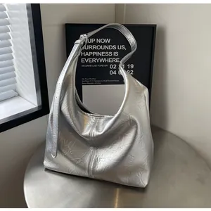 Détail de la texture argentée froissée et de la boucle en métal sur le sac cabas