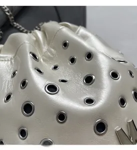 Gros plan détaillé du sac seau blanc avec œillets argentés et logo M métallique