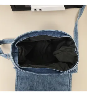 Vertical view of the spacious black interior and lining of the blue denim shoulder bag