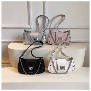 Detail view of crocodile pattern underarm bags in silver, pink, black and white colors