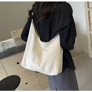 Détail macro du sac hobo blanc crème montrant la texture plissée en similicuir et sa capacité
