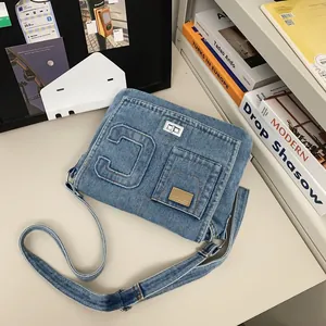 Minimalist blue denim crossbody bag with C letter patch and adjustable shoulder strap