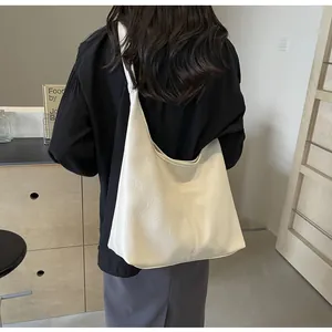 Sac fourre-tout beige minimaliste avec texture plissée porté pour l'échelle