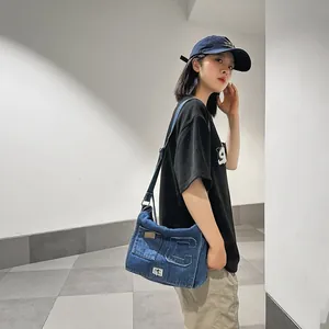 Minimalist washed denim shoulder bag in navy blue with a large C letter and metal lock