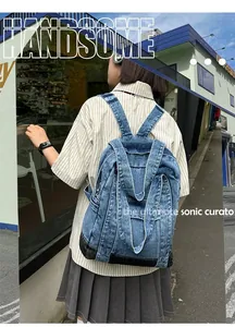 Detail of blue denim backpack with classic washed finish and adjustable straps on a model