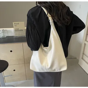 Détail du sac hobo en cuir plissé blanc avec boucle métallique sur la bandoulière