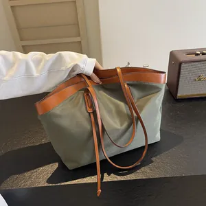 Army green large tote bag with brown leather handles shown in a lifestyle setting
