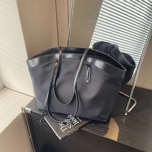 Minimalist large black canvas tote bag with leather trim for women shopping or commuting