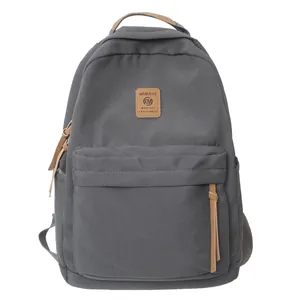 Dark grey casual canvas backpack for students with brown leather accents and side pockets