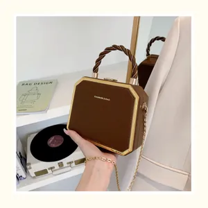 Détail d'un sac carré vintage marron avec cadre doré et poignée en corde torsadée