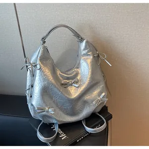 Detailed view of silver crumpled texture hobo bag with multiple cute bow decorations