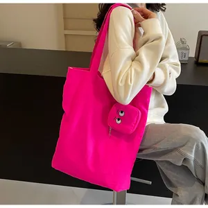 Detailed shot of rose pink canvas tote bag with matching embroidered monster eye pouch