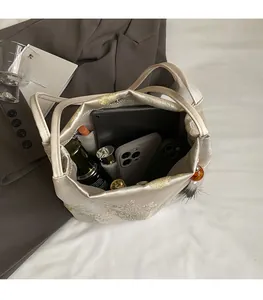 Interior view of floral embroidered tote bag showing large capacity for tablet and cosmetics