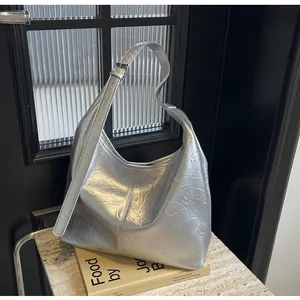 Détail du sac cabas argenté métallisé avec bandoulière réglable et texture plissée