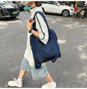 Deep blue denim backpack showing spacious side pockets and durable construction in use