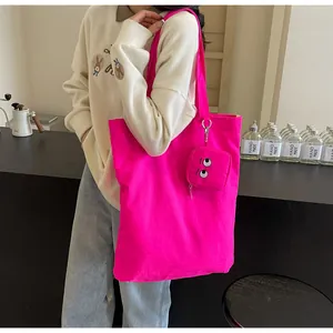 Rose pink canvas tote bag with embroidered eye coin purse detail in everyday use