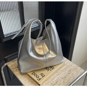 Vue détaillée du sac hobo argenté à texture froissée avec bandoulière et anses chic