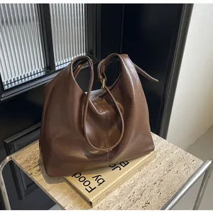 Détail du sac cabas en similicuir marron foncé avec anneau métallique et bandoulière