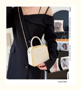 Sac octogonal beige avec cadre en métal doré et détail élégant de poignée torsadée