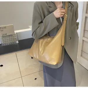 Détail du sac cabas en cuir plissé kaki avec large bandoulière et boucle en métal doré