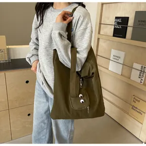 Detail of olive green canvas tote bag with monster eye coin purse and large capacity