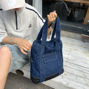 Classic dark blue denim tote bag with external flap pocket and durable black base panel