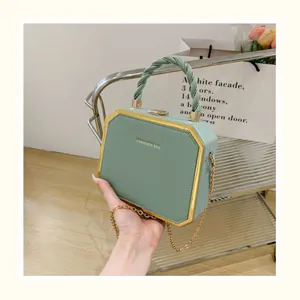 Détails du sac à main vert avec cadre métallique doré et poignée supérieure en spirale