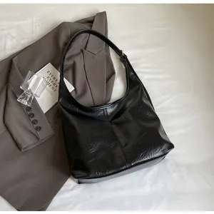 Détails du cabas noir minimaliste en cuir froissé avec des finitions en métal doré