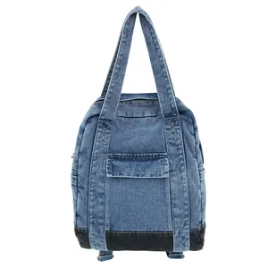 Blue denim backpack with black base and front pocket in a clean white background view