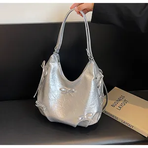 Detail of silver tote bag with metallic crinkle leather and bow knot decorations