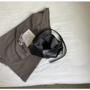 Vue de dessus du grand sac Hobo noir montrant le cuir souple et le fermoir magnétique